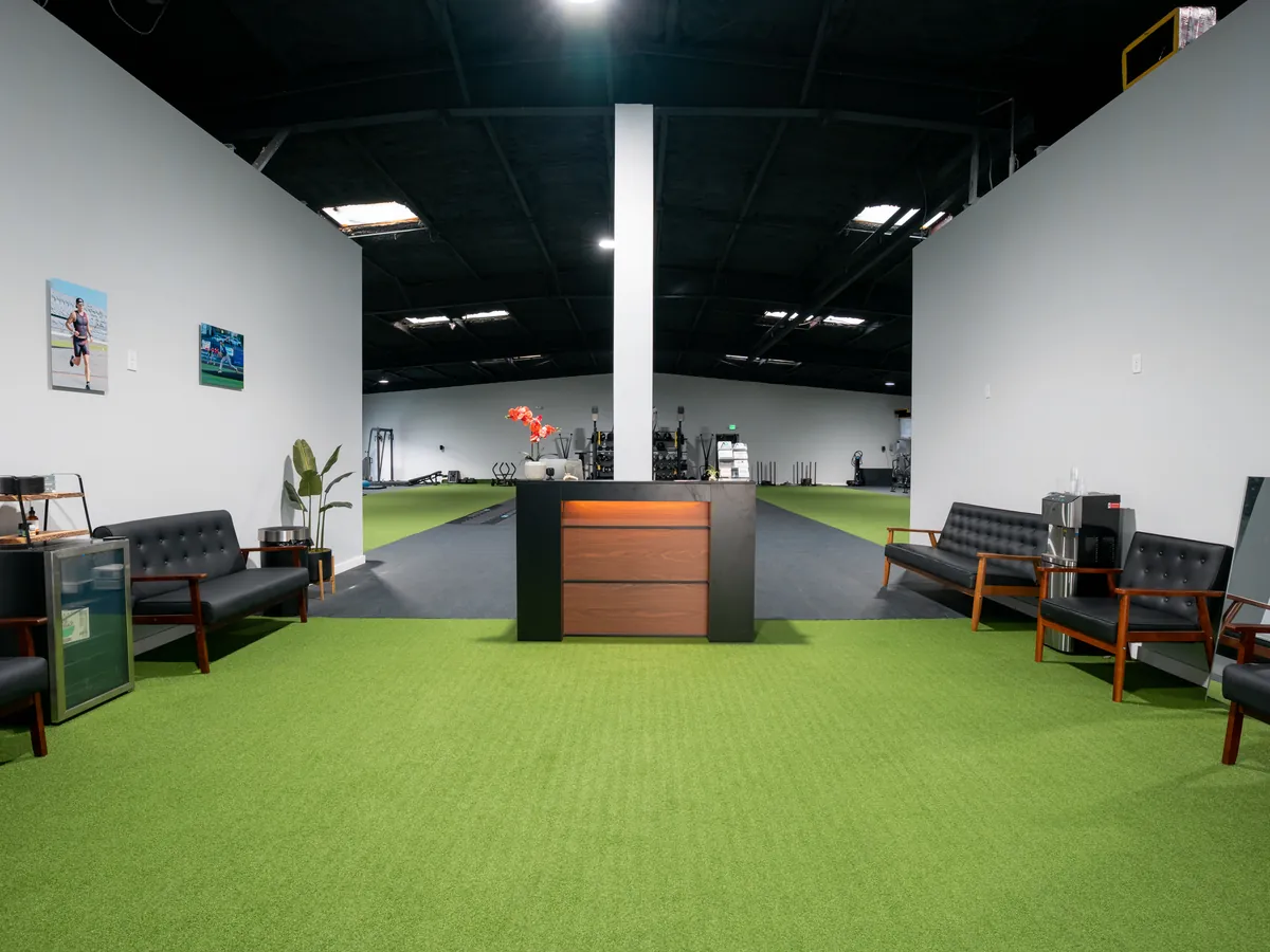 Athlete Pro front desk with lobby seating beside the turf training floor