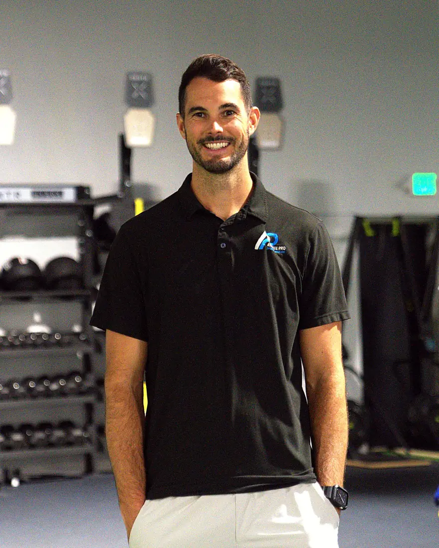 Dr. Frank Freijomil, PT, DPT, Physical Therapist at Athlete Pro Sports Medicine in Sarasota, FL, smiling in the clinic training area
